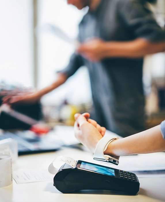 Klant betaalt bij een kassaterminal, ondersteund door retailtechnologie-oplossingen van TRG